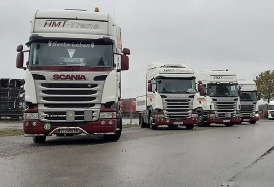 Vier weiße HMT-Scania Sattelzugmaschinen in einer Reihe