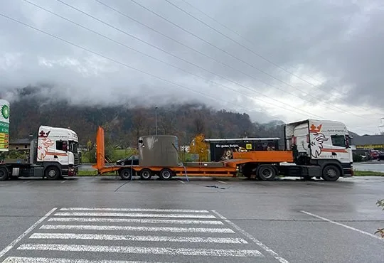 HMT-Sattelzug mit orangem Tieflader und Sonderladung auf einem Parkplatz